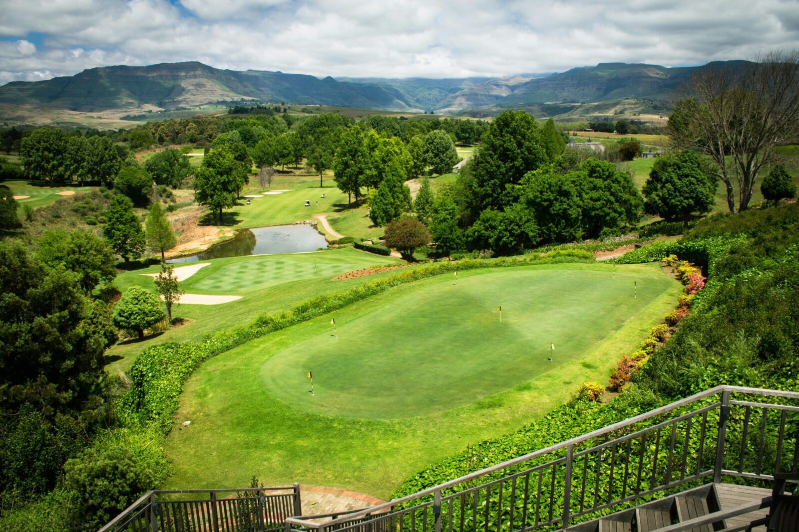 Home Aerial view of a picturesque golf course with lush greenery and scenic hills, perfect for sports and leisure.